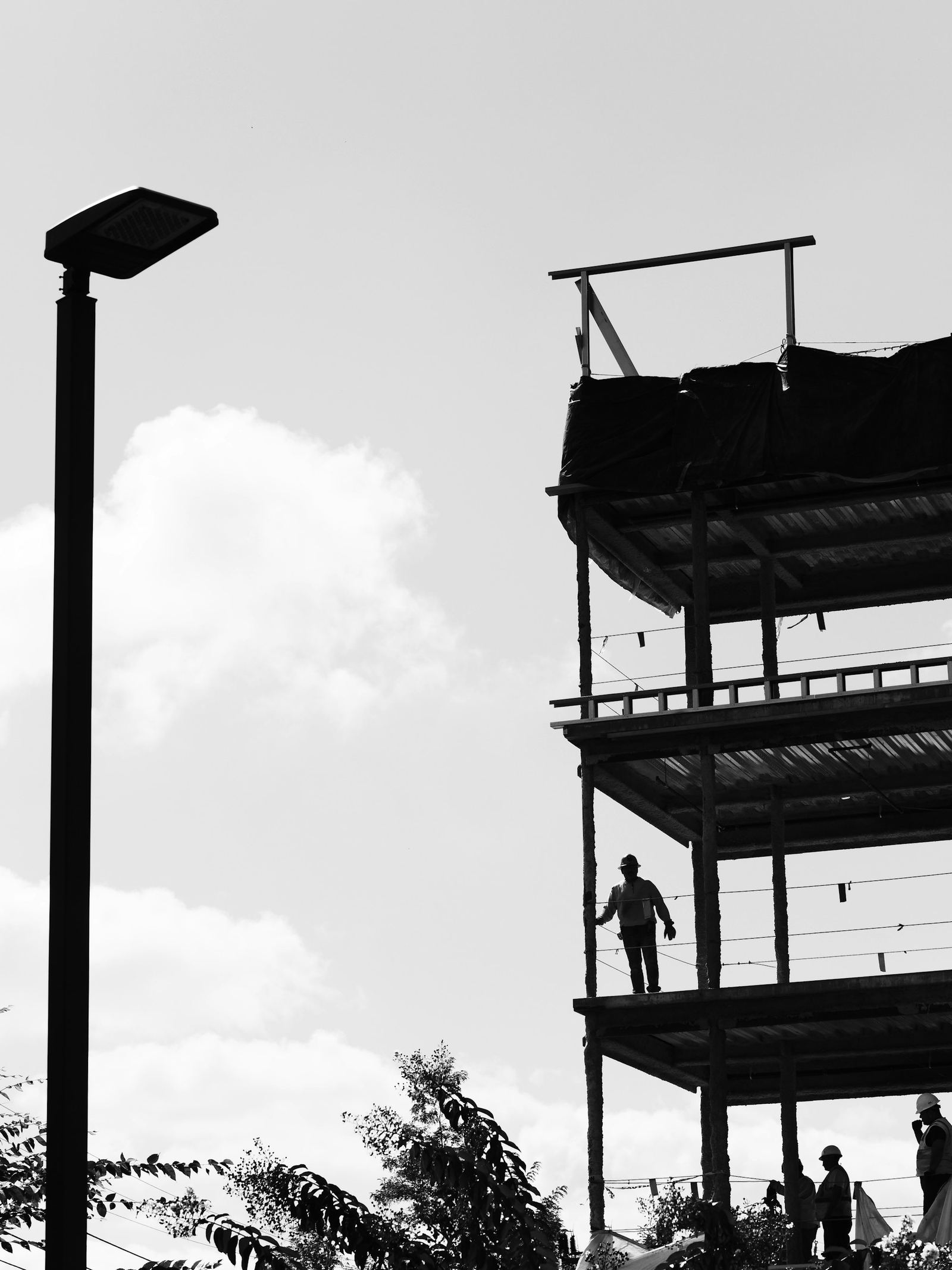 Silhouetted crew on an unfinished frame
